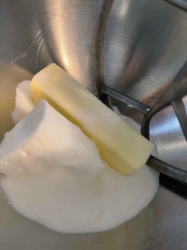 butter and sugar being mixed in a mixing bowl