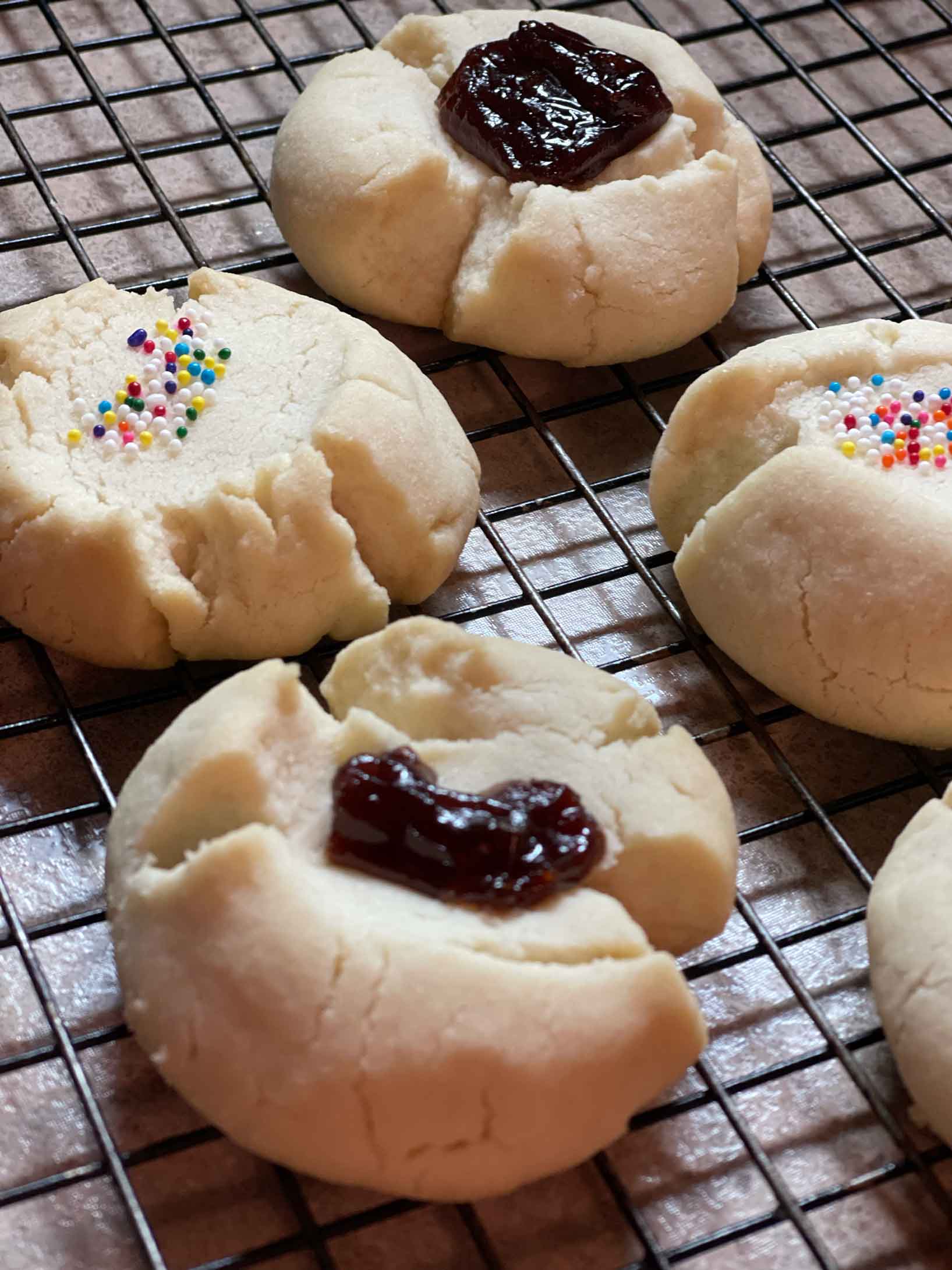 Puerto Rican cookies on wire rack with guava paste and sprinkles