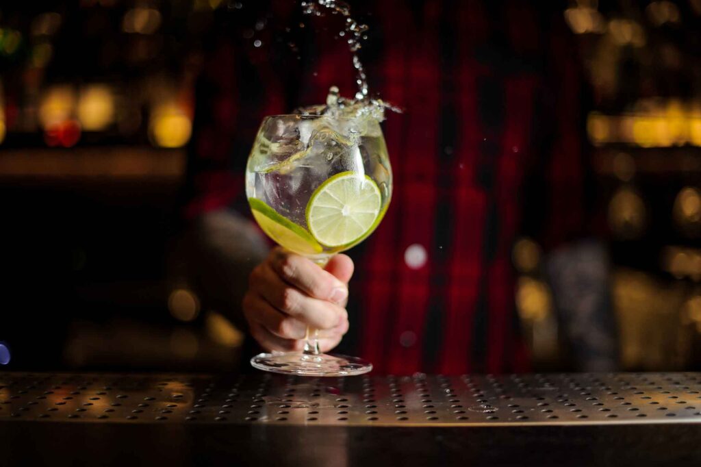 keto gin drinks. picture of gin being poured into a glass with lime slices