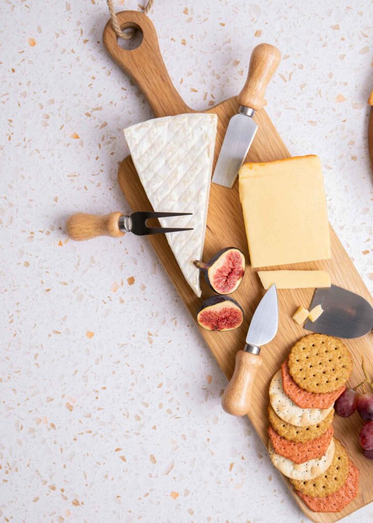 picture of cheese and crackers on a wooden board for a party