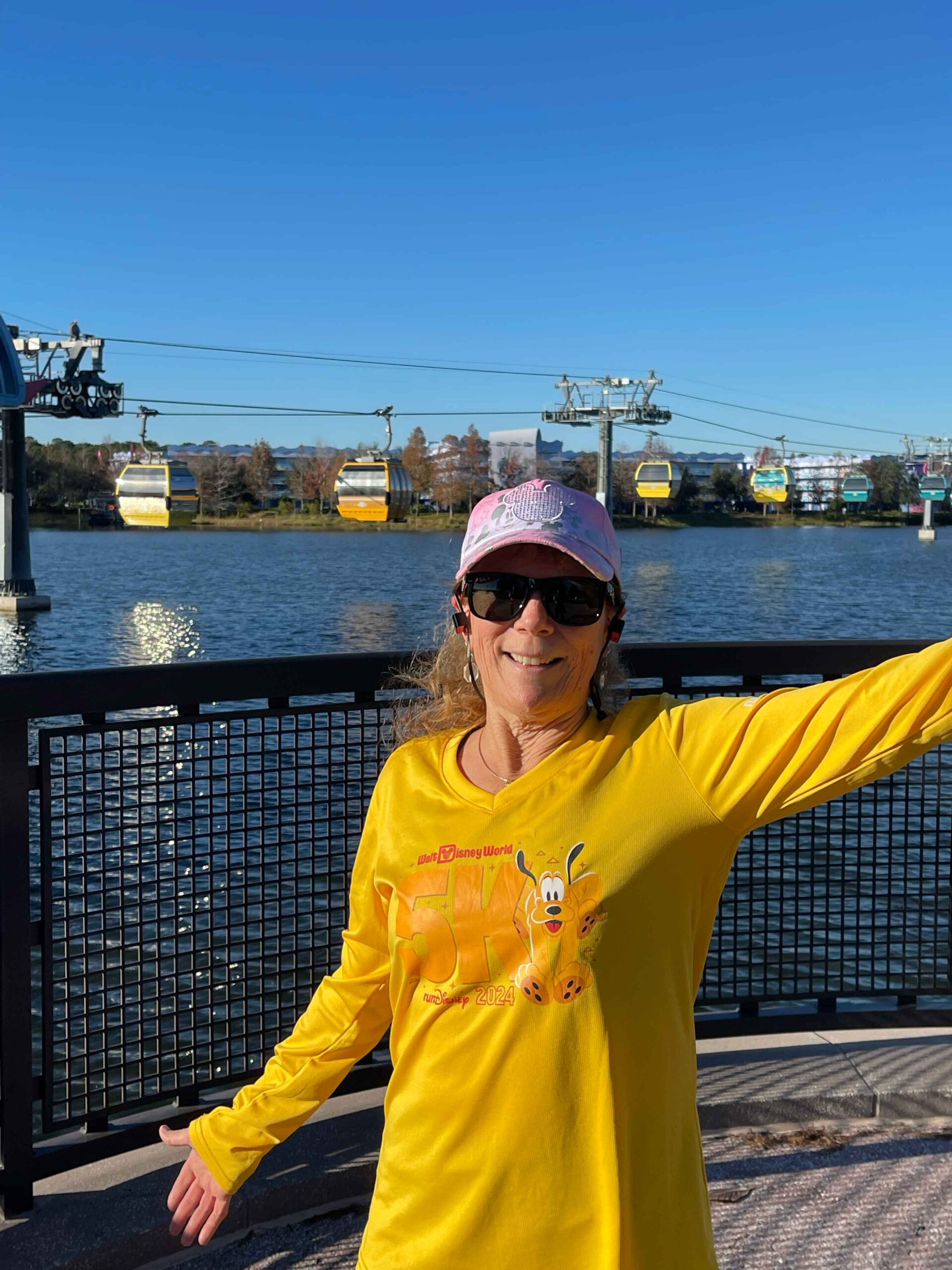 Me outside of Hour Glass Lake with the Skyliner in the background after finishing a virtual 5k disney run