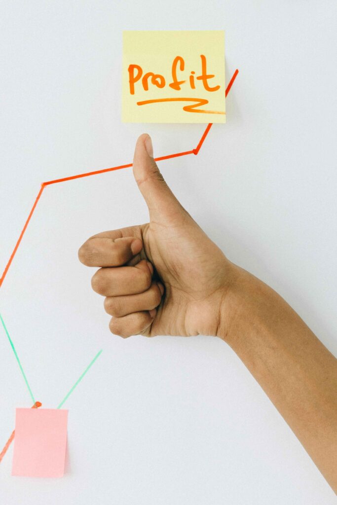 profit on a stickie with a person's thumbs up and upward graph line