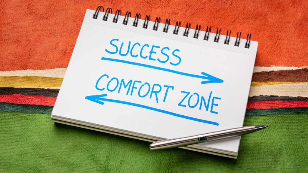 Why the Comfort Zone is Your Enemy - a spiral notebooks with the word success and a forward arrow and the words comfort zone backwards arrow