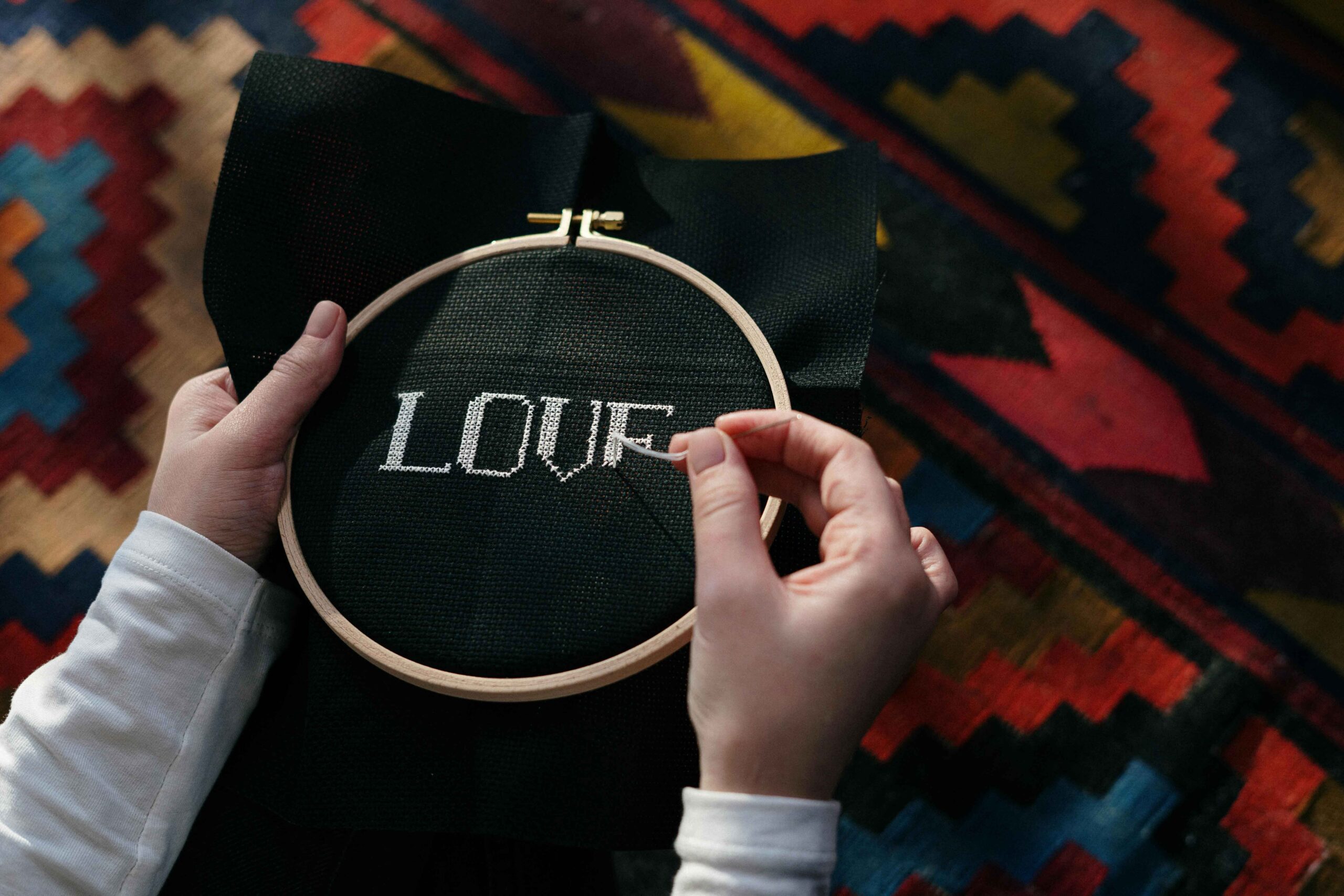 Turn Your Passion into a Business - a picture of a an embroidery hoop with a woman stitching the word LOVE