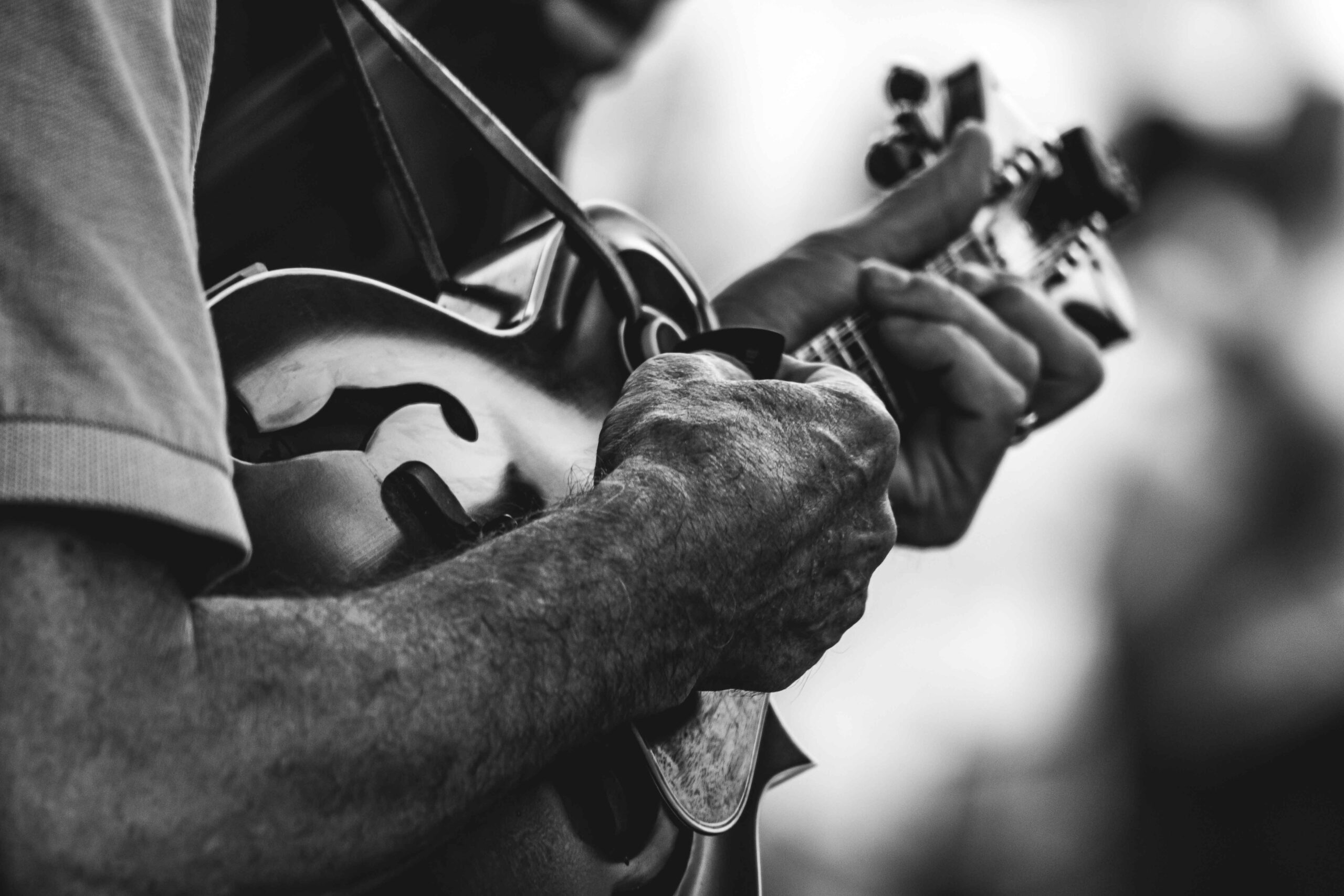 a black and white photo of a man playing the mandolin. bluegrass festivals in maryland