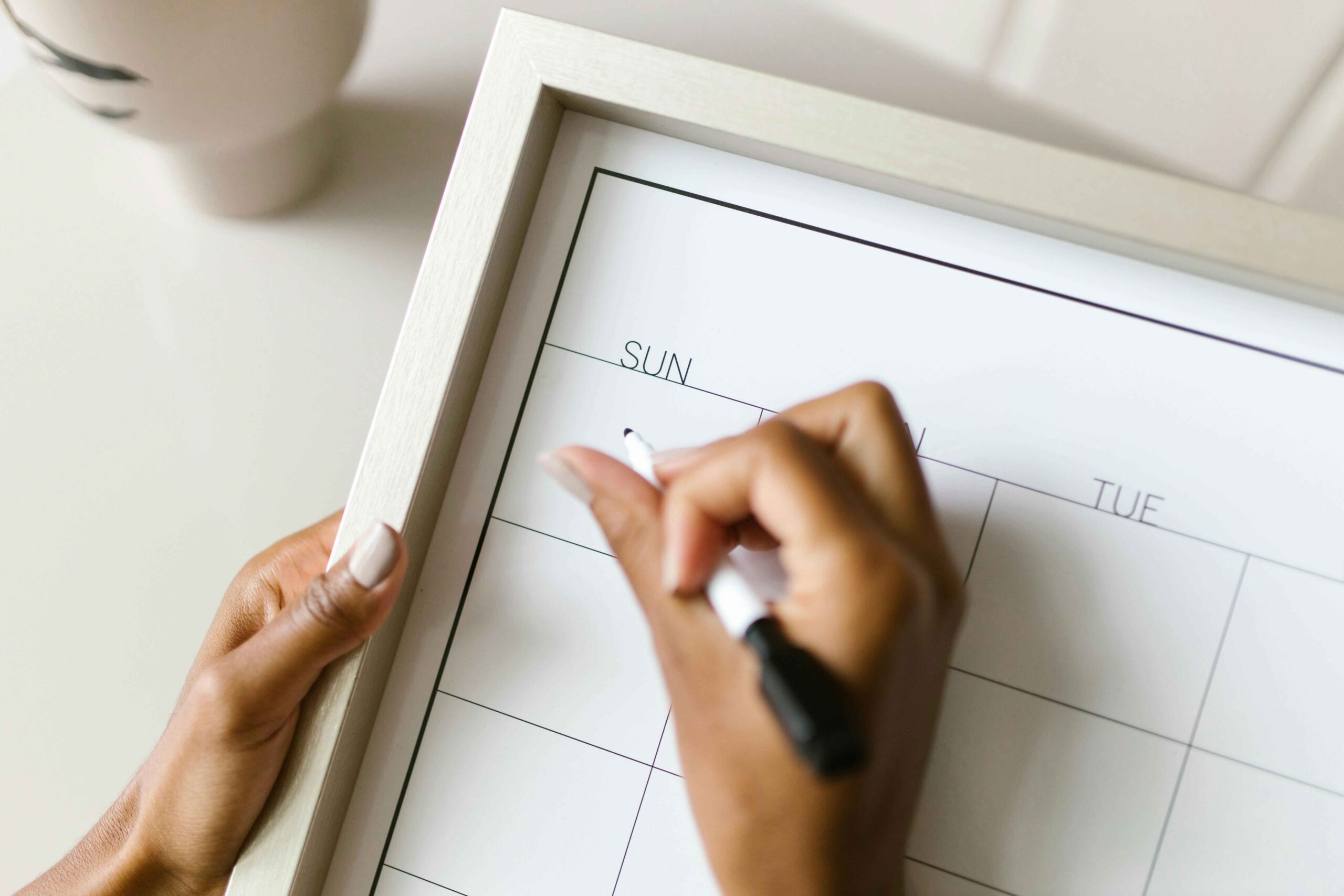 beat the sunday scaries. a woman's hands holding a marker over an blank calendar showing sunday